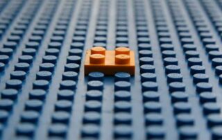 orange lego on top of a blue lego